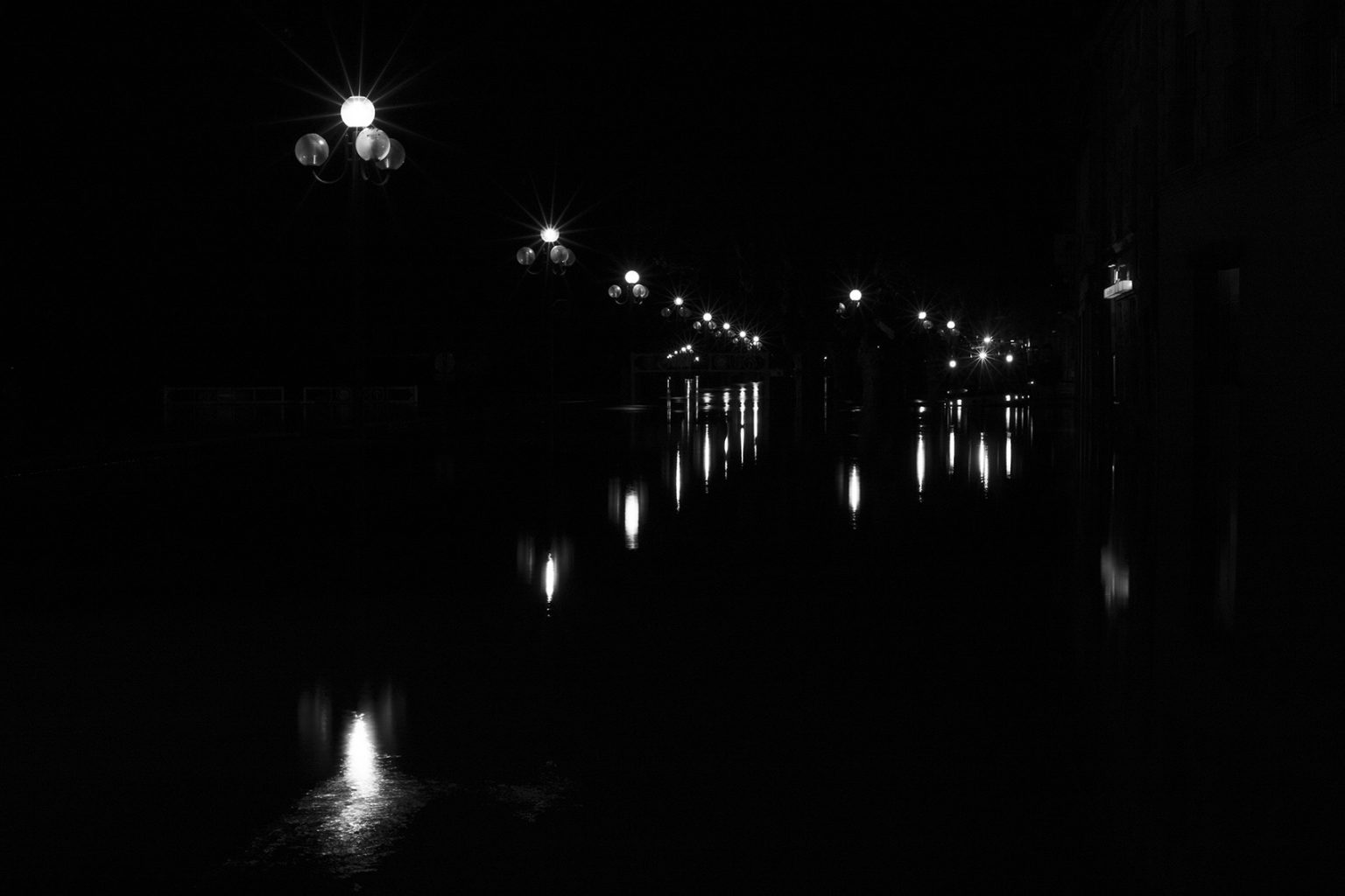 Lumières dans le noir avec des lampadaires qui reflètent dans l'eau