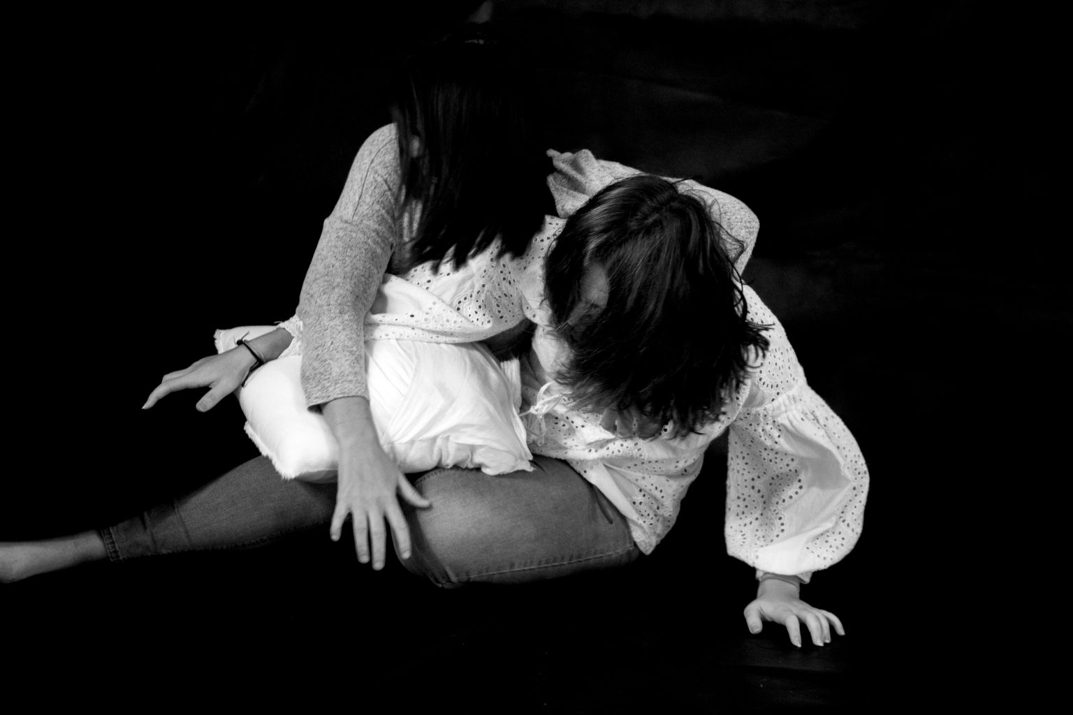 Définition de la photographie par Muriel Joly. Bataille de polochon entre filles sur une photo en noir et blanc en mouvement pour une séance de photos en famille