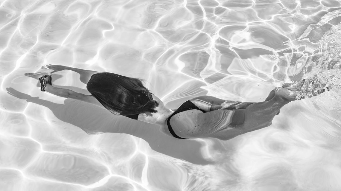 plongeon d'une femme en bikini dans une piscine en photo noir et blanc