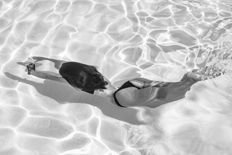 plongeon d'une femme en bikini dans une piscine en photo noir et blanc