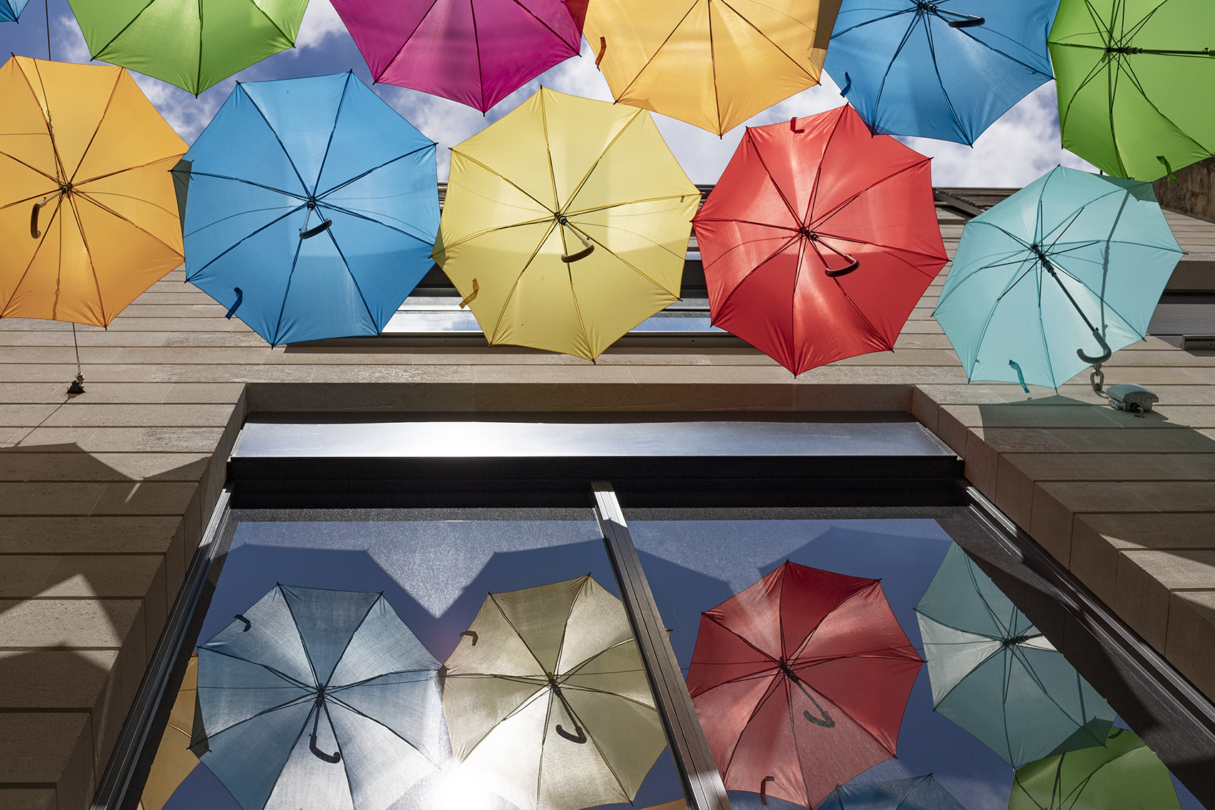 parapluies colorés suspendus dans bordeaux avec reflet dans les vitres objectif et boitier canon